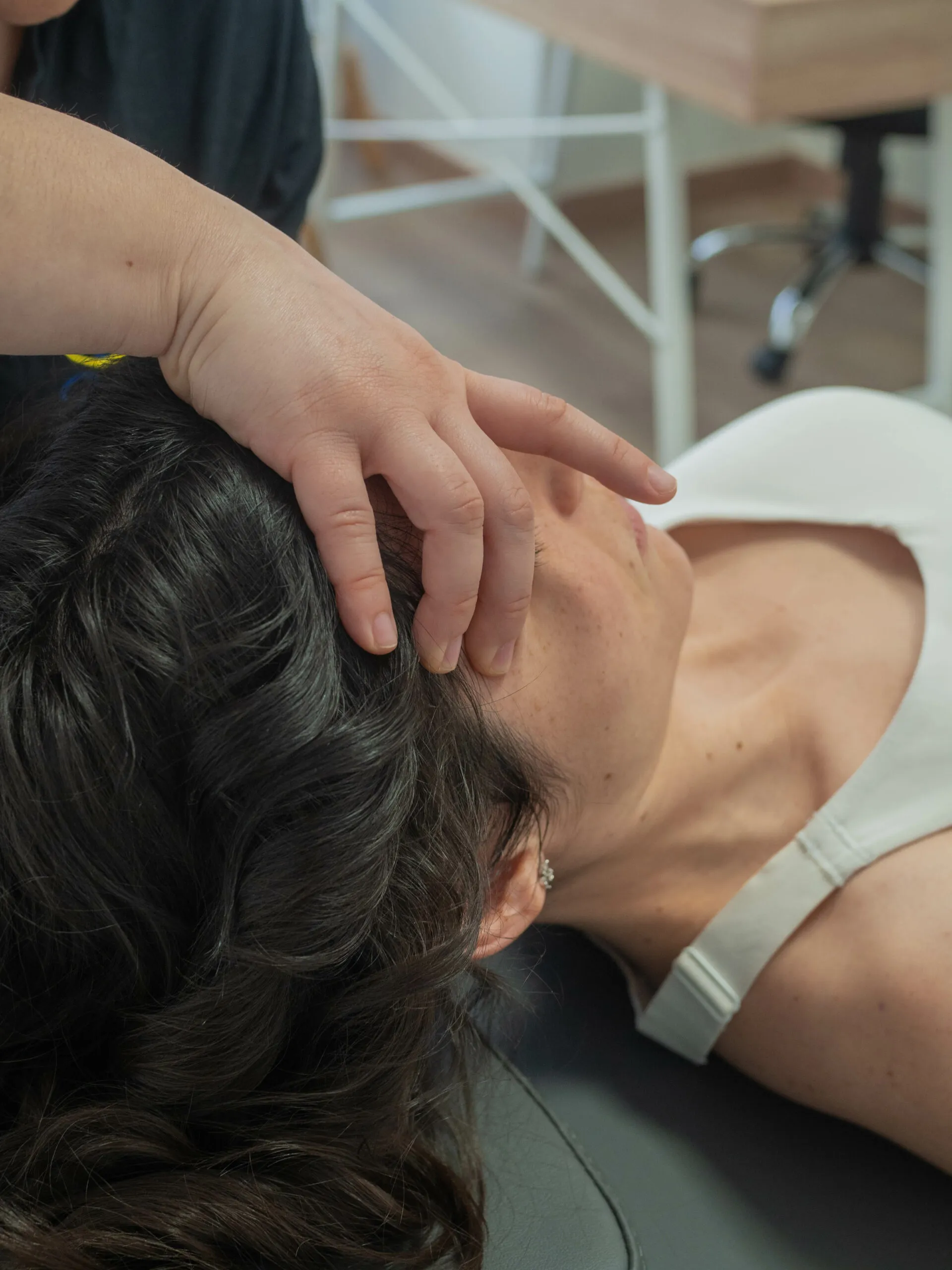 Judit aplicando una técnica de osteopatía cervical a una paciente en la clínica